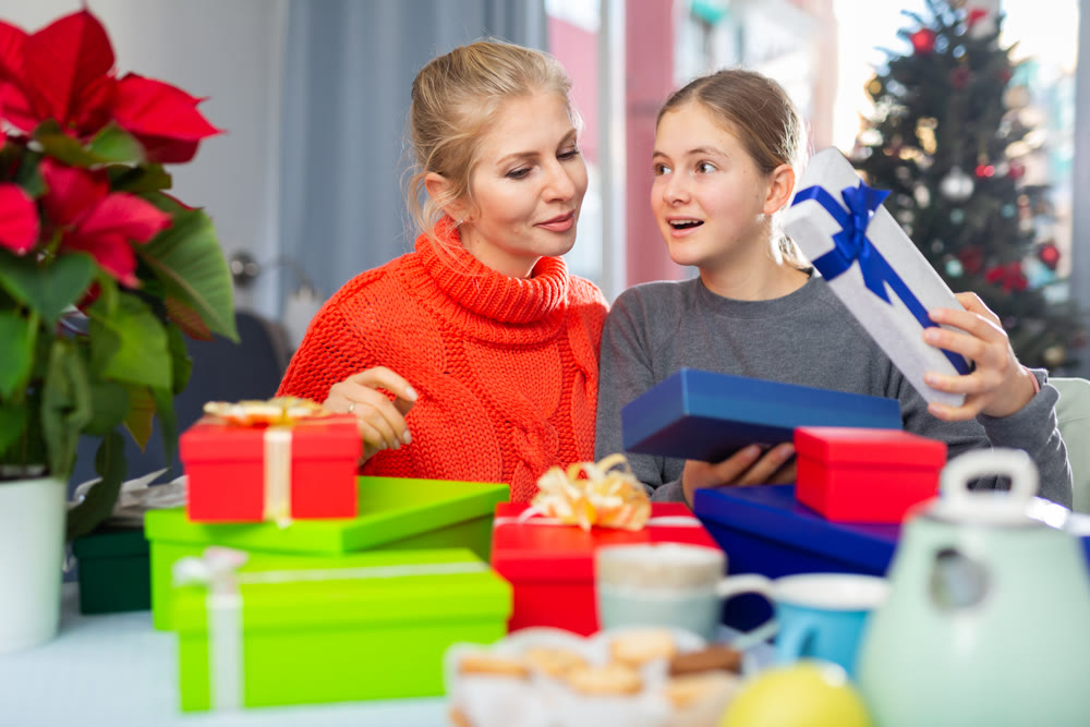 Mom and daughter unpack gifts during christmas