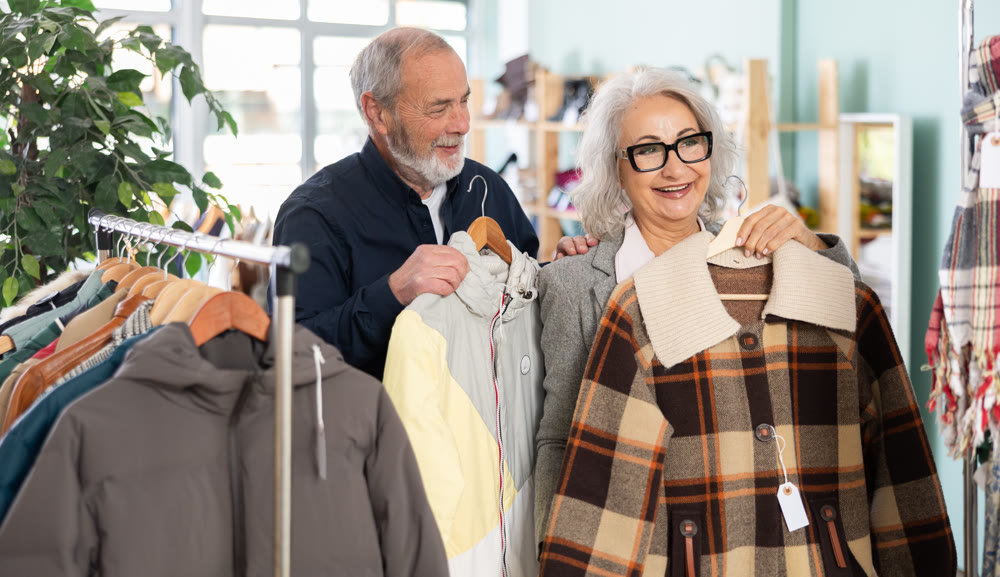 Elderly couple choosing jackets and coats together