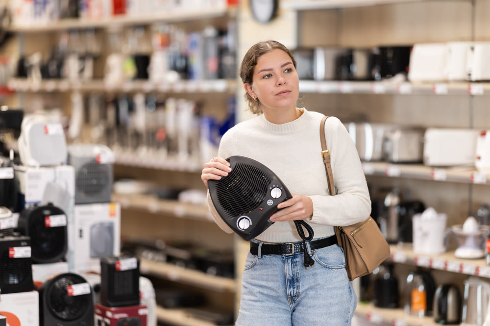 Young woman buying heater from hardware store