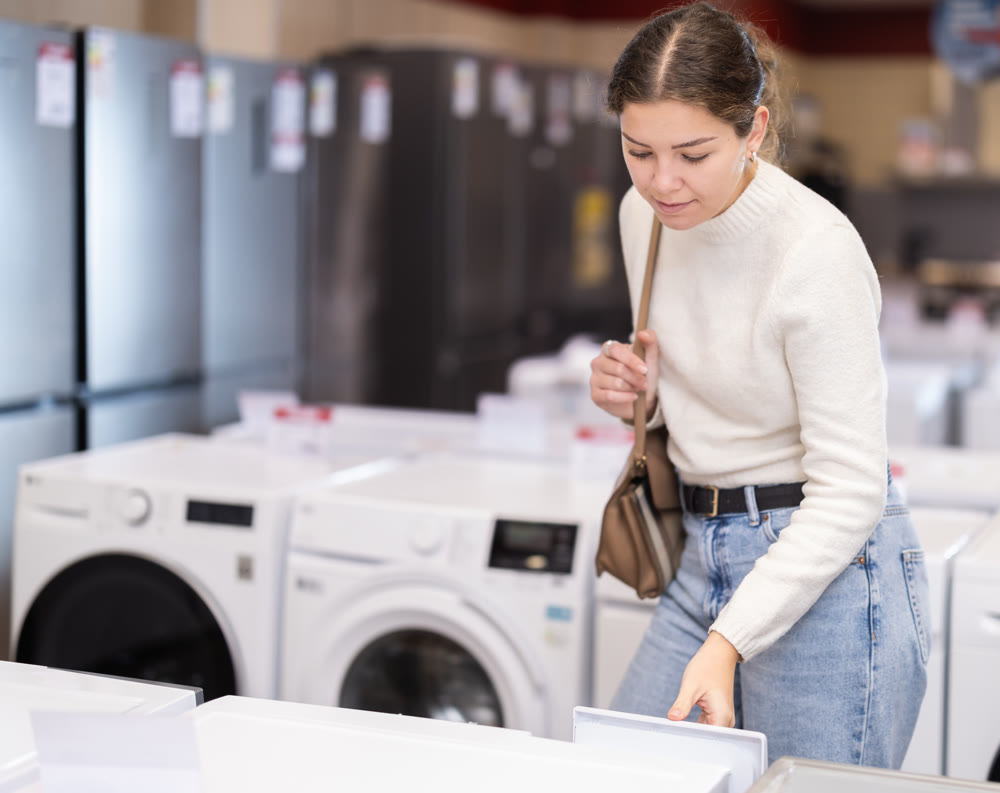 Girl customer inspect product range and selects dishwashing machine or washing machine