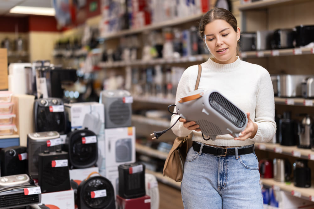 Girl customer inspect product range and selects fan heater