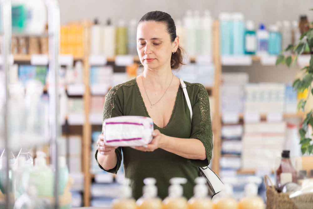 Woman are busy choosing feminine pads at pharmacy