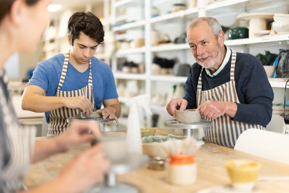 Young woman and man and elderly man crafting ceramics