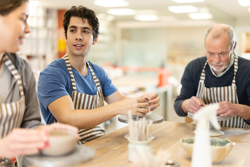 Young woman and man and elderly man crafting ceramics
