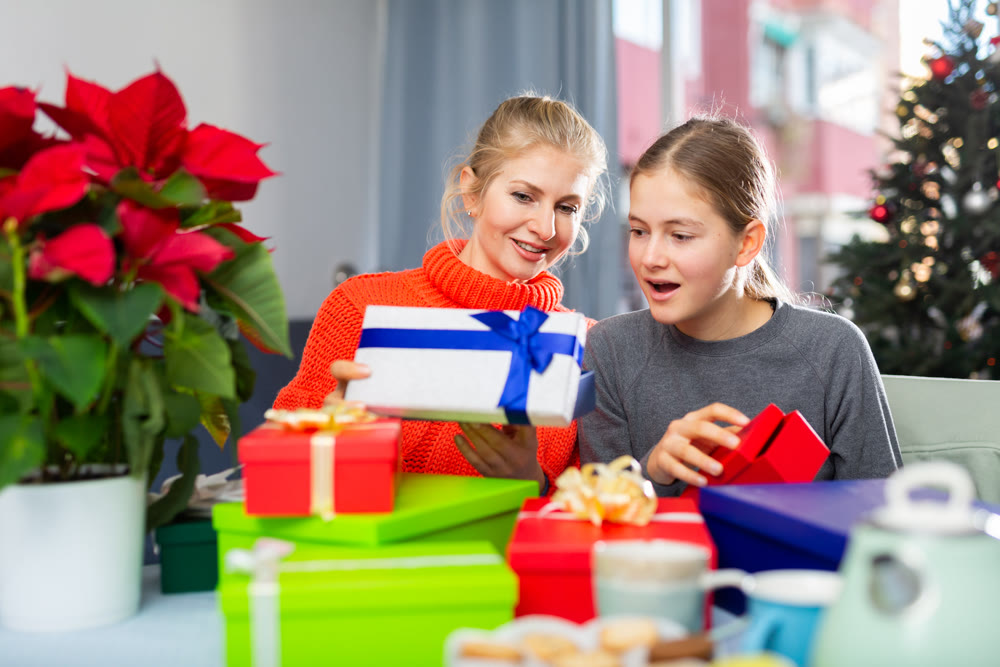 Woman and her daughter opens Christmas gift boxes