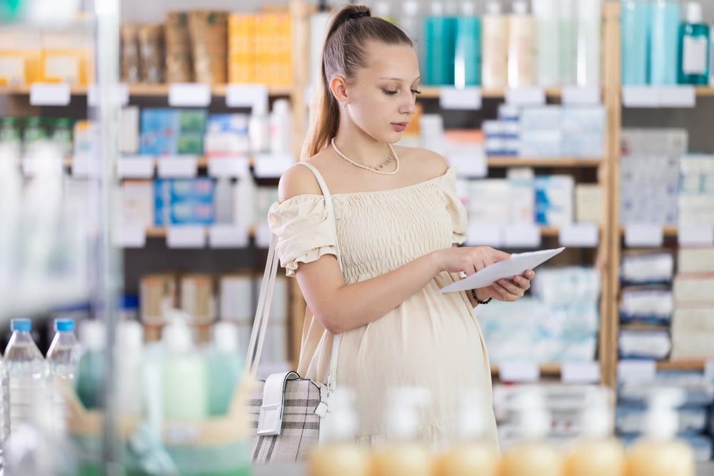 Pregnant woman with prescription in drugstore