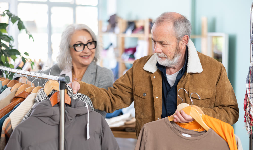 Mature married couple chooses fashionable t-shirt in clothing store