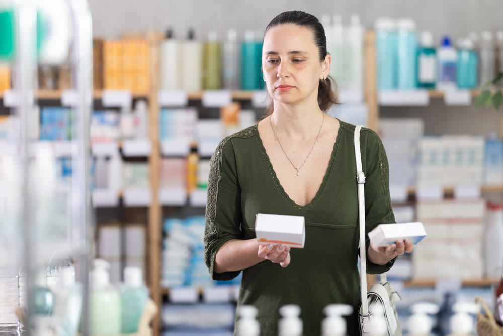woman chooses packages of pills in a pharmacy