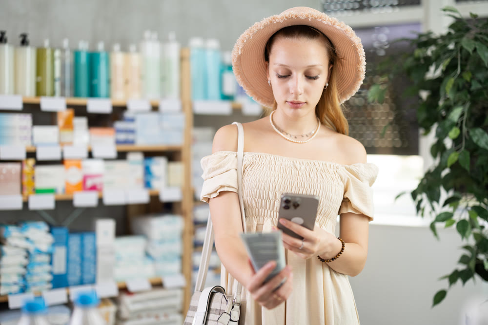 Young pregnant woman scans a package of cream