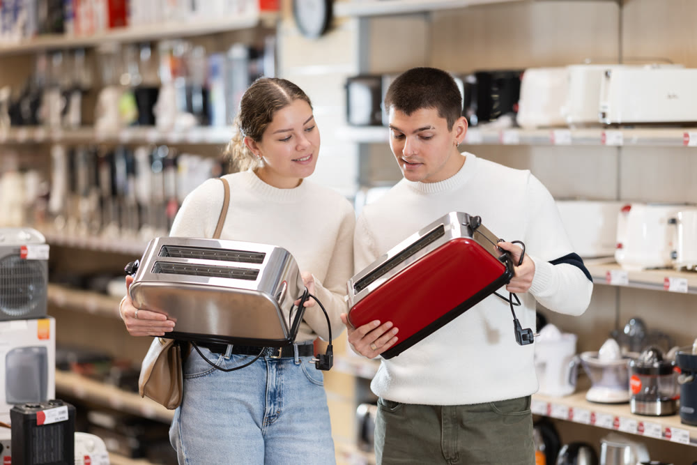 Couple customer inspect product range and selects toaster