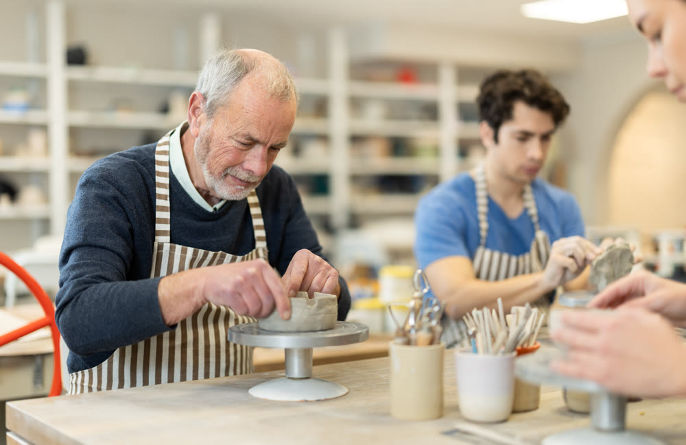 Young woman and man and elderly man crafting ceramics