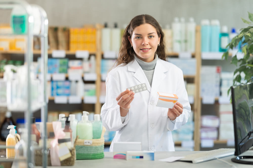 Young woman pharmacist offering pills