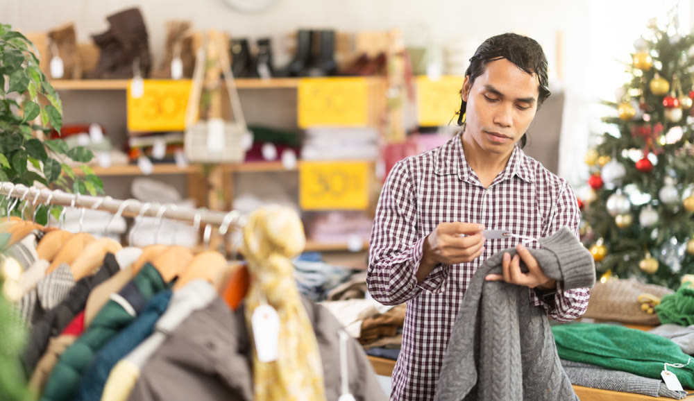 In chain shop, Indonesian man choose sweater, X mas shopping