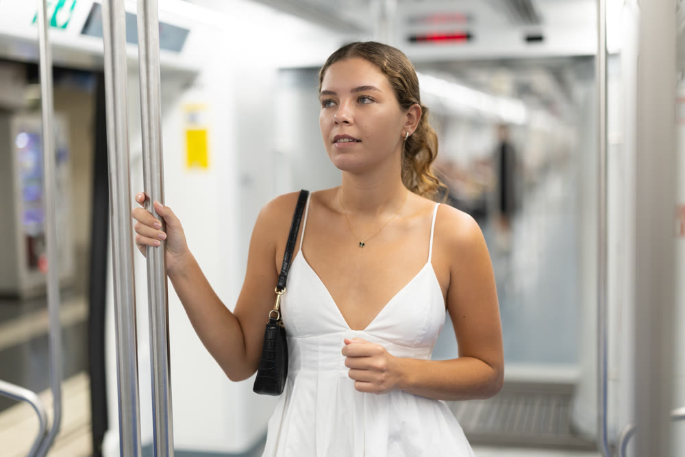 Calm young girl standing on wagon travelling by subway