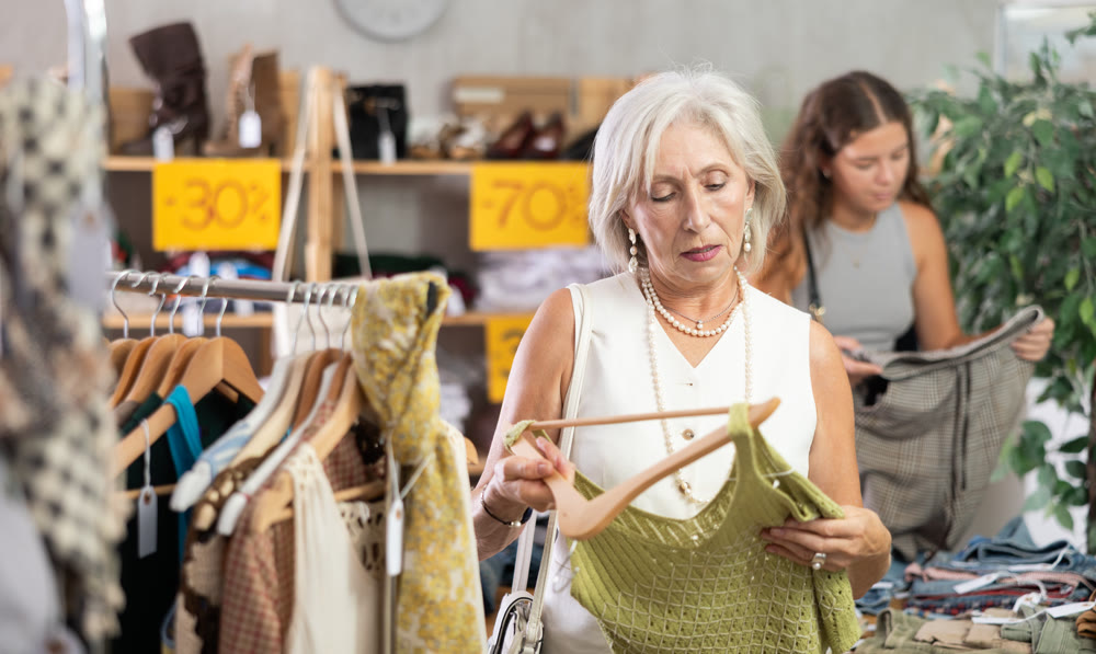 Elderly woman chooses top in clothing store