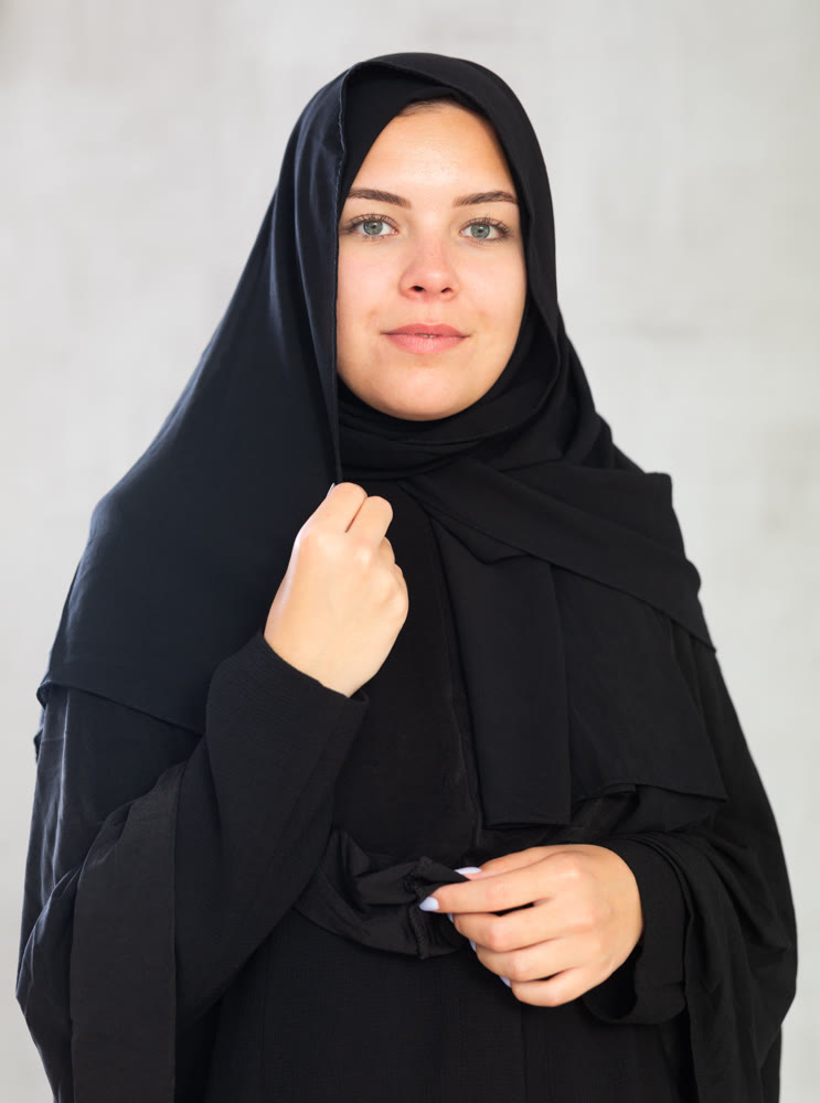 Smiling young woman dressed in traditional islamic clothes