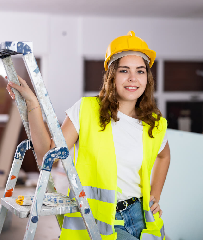 Smiling young female civil engineer standing at construction site