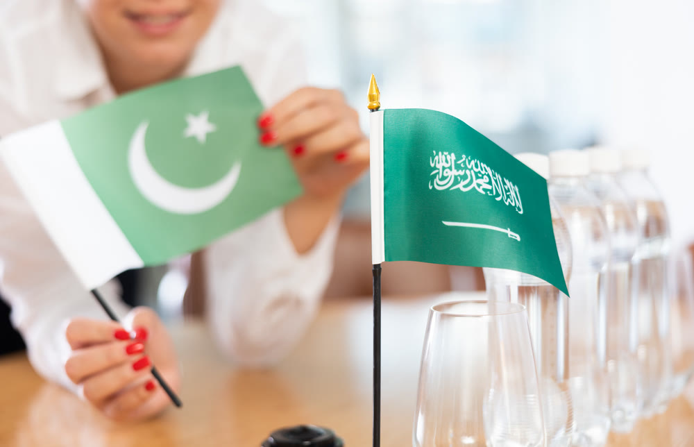 Flags of Pakistan and Saudi Arabia stand on negotiating table in office