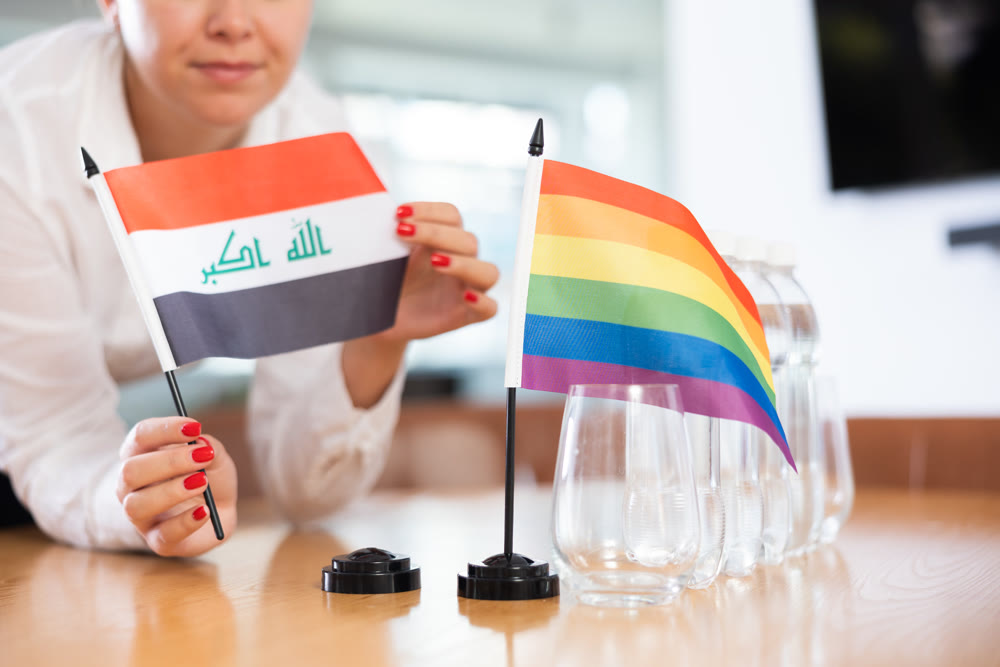 Rainbow flag and national flag of Iraq on negotiating table