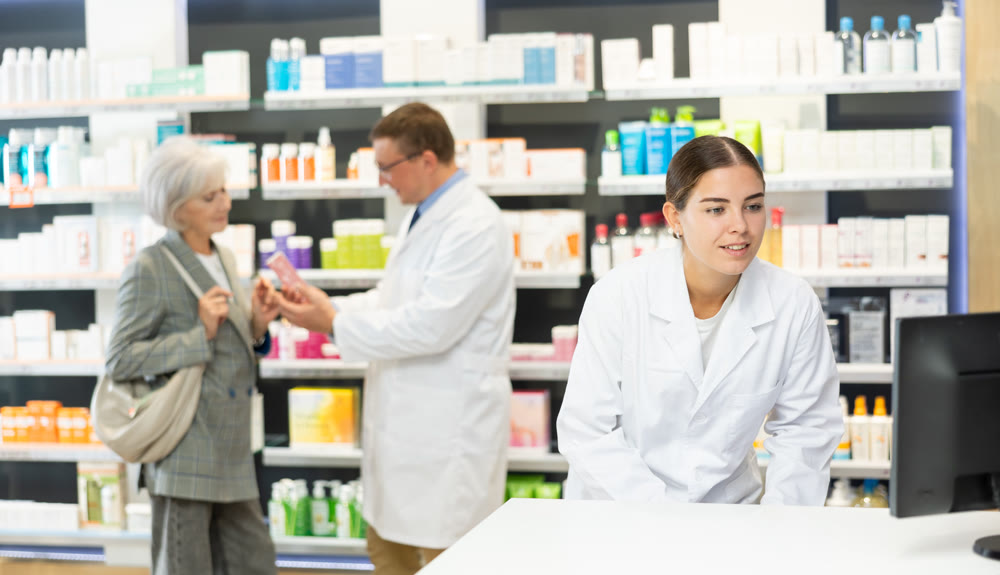 Female pharmacist in medical uniform posing while working in pharmacy
