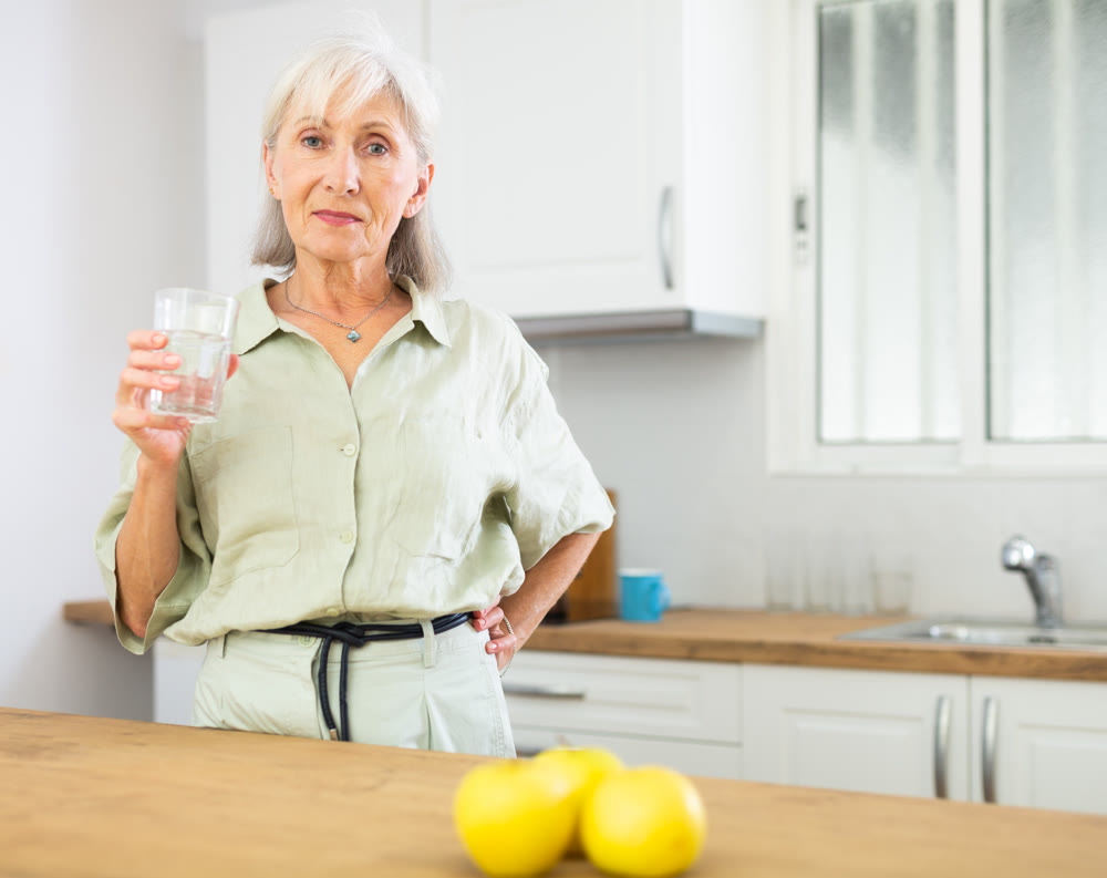 Smiling mature woman with glass of water