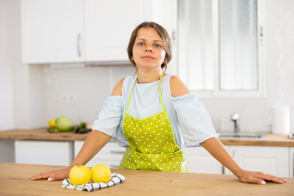 Young attractive landlady posing in modern kitchen