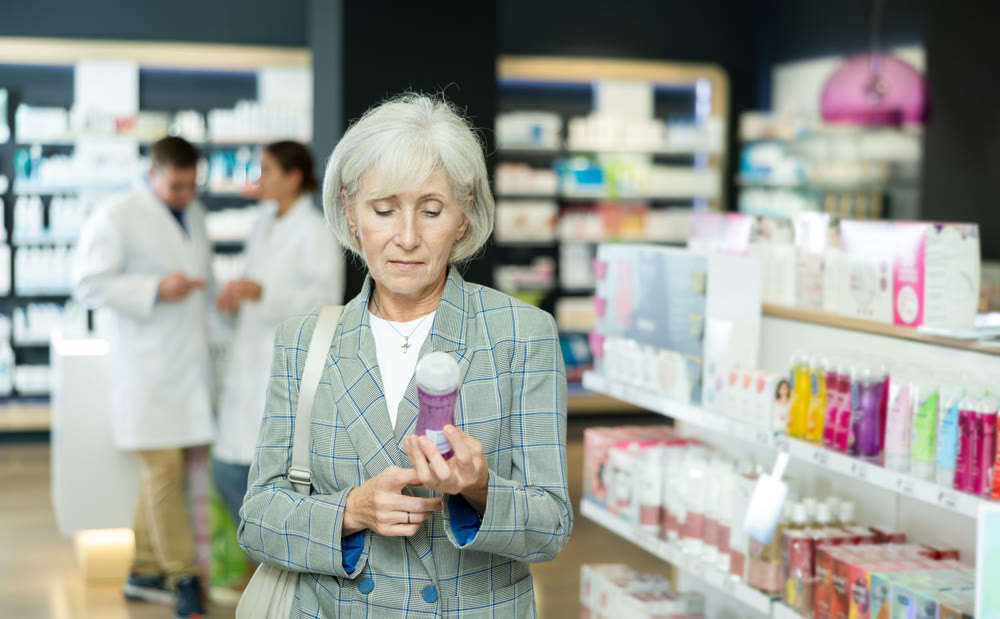 Mature woman chooses lubricant and intimate hygiene items in pharmacy