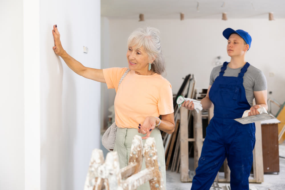 Mature woman checks the construction work performed by a fifteen-year-old worker