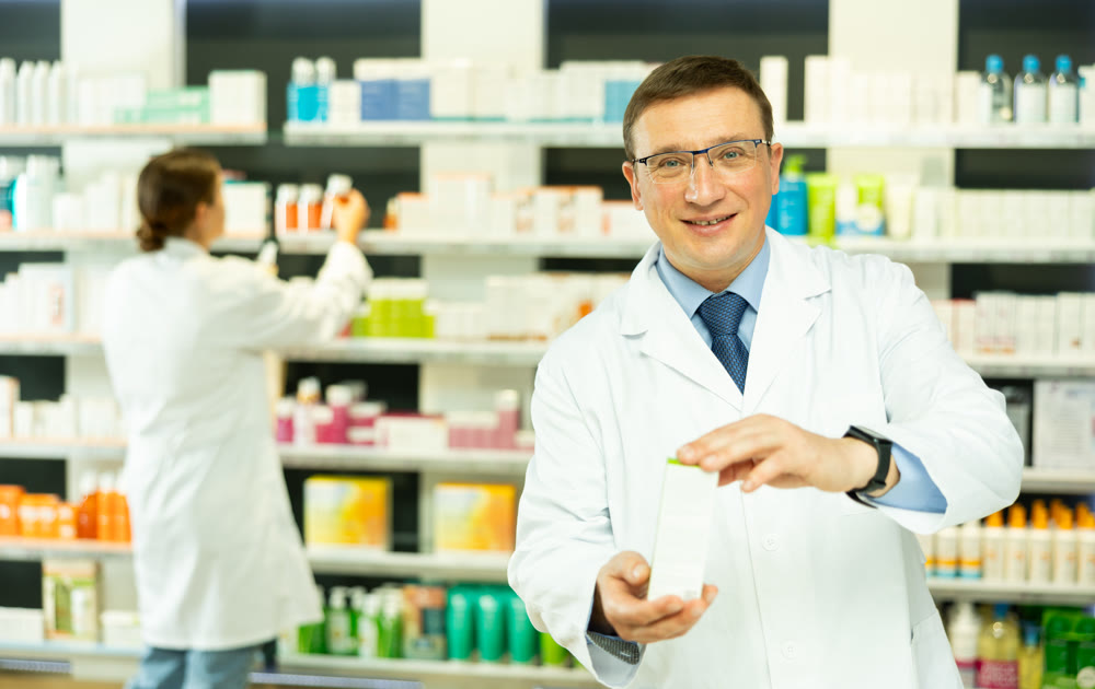 Middle-aged male pharmacist demonstrating preparation in box