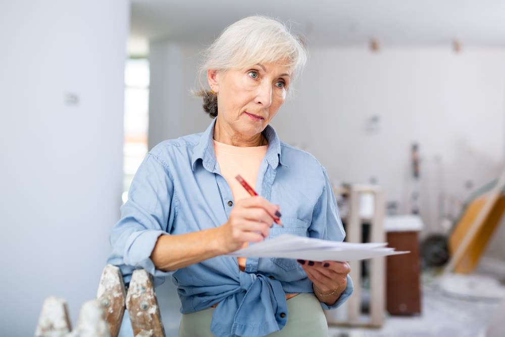 Mature woman making notes at renovating house
