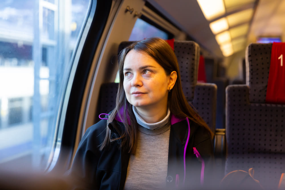 Woman looking through window while traveling by train