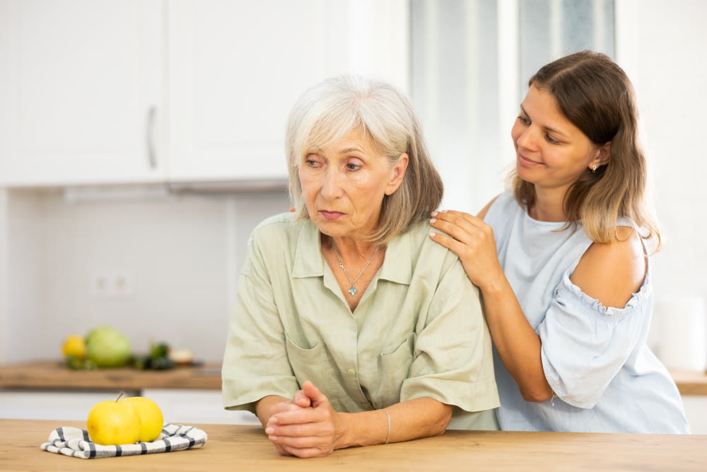 Woman consoling her depressed elderly mother