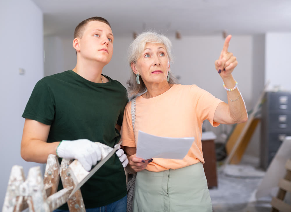 Teenager helping senior woman with home improvement works