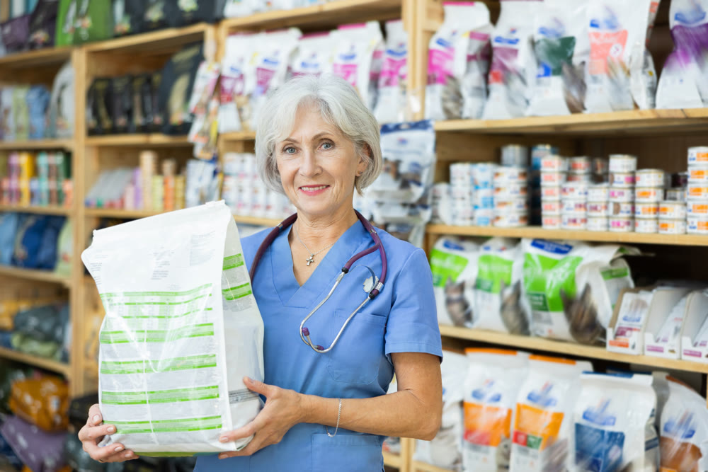 Smiling female veterinarian holding bag with healthy dry pet food