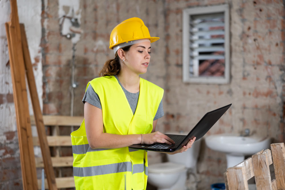 Female civil engineer using laptop at construction site indoors