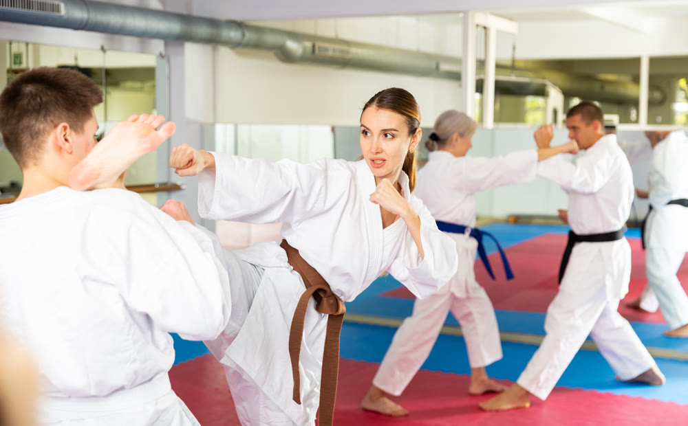 Woman sparring during group karate training