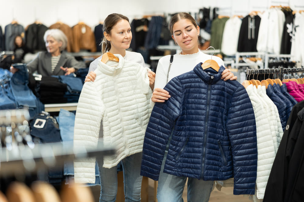 Young and adult women choosing jacket in store