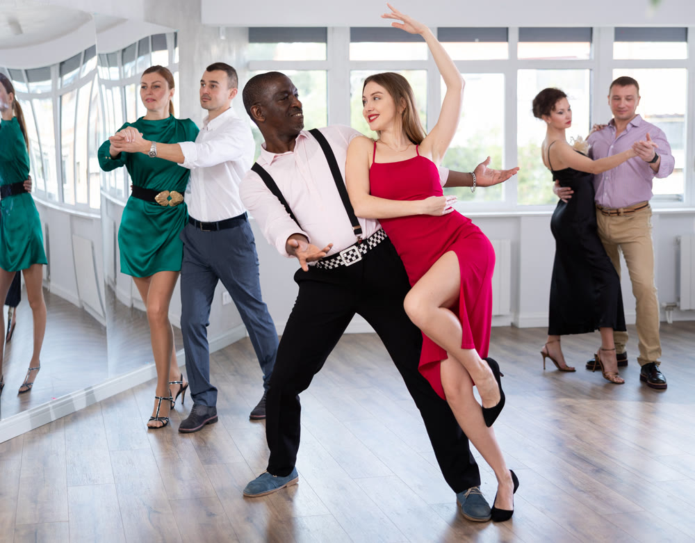 Man and young woman practicing waltz in dancing studio