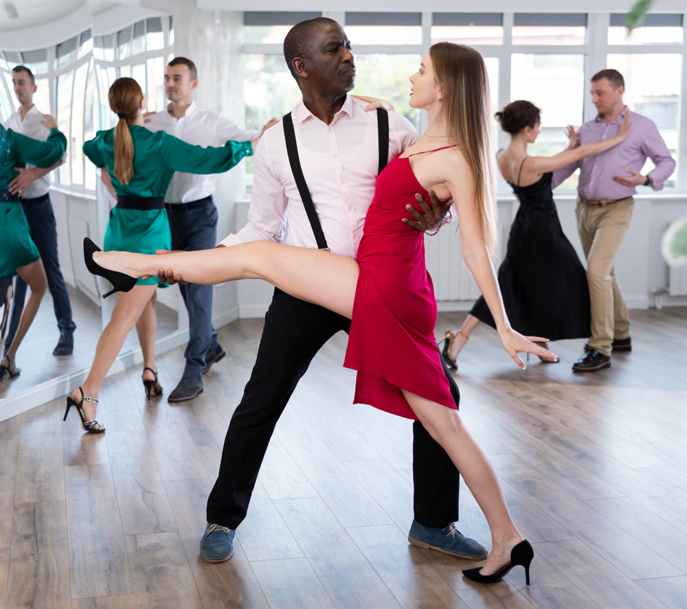 Woman dances incendiary tango with African man partner during choreography lesson