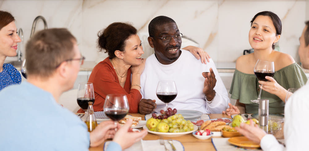 Multiethnic women and men friends chatting and drinking