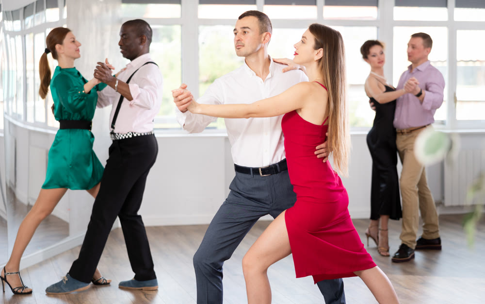 Couples dancing tango, enjoying dance moves in dance salon