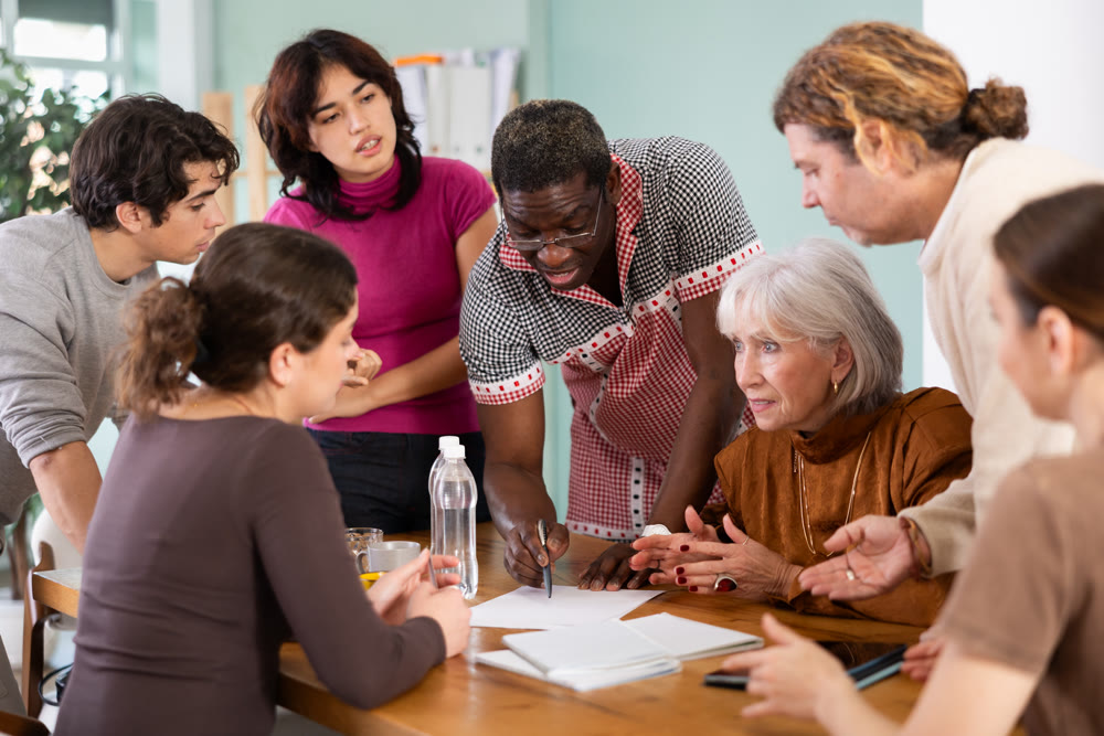 group of people look at documents and discuss questions