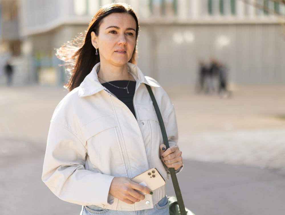 Girl traveler with phone walks through tourist area of town