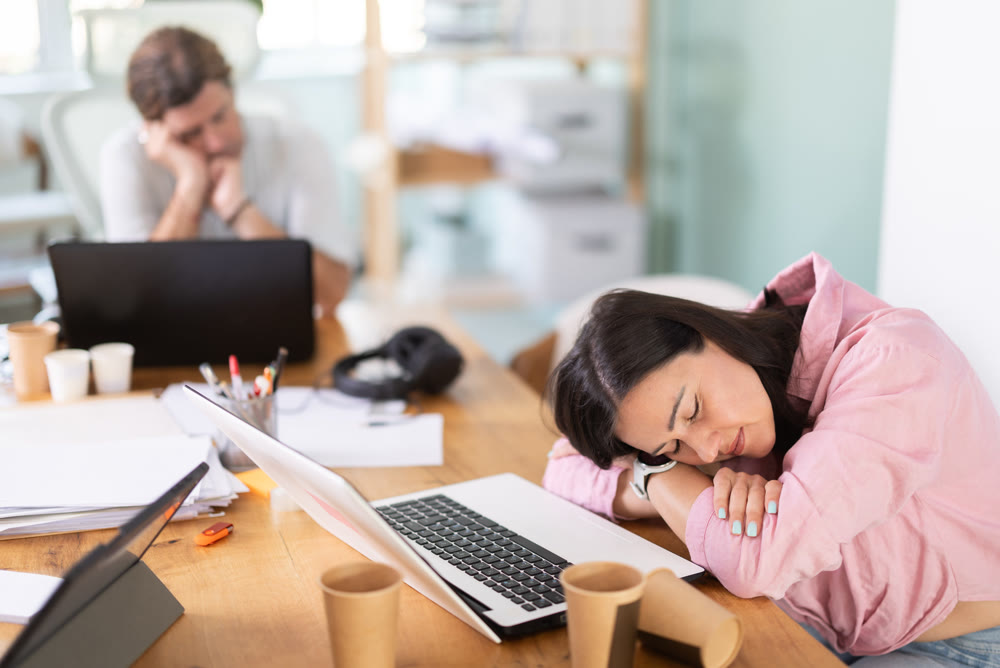 Tired woman fell asleep at his desk in office