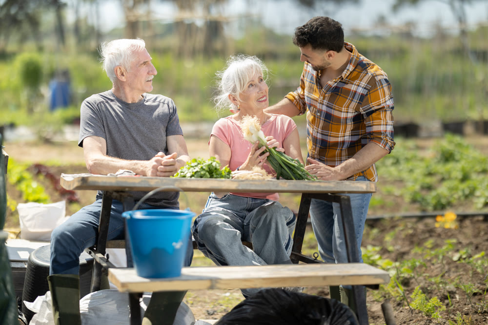 Happy family of farmers sits at table and discusses current affairs
