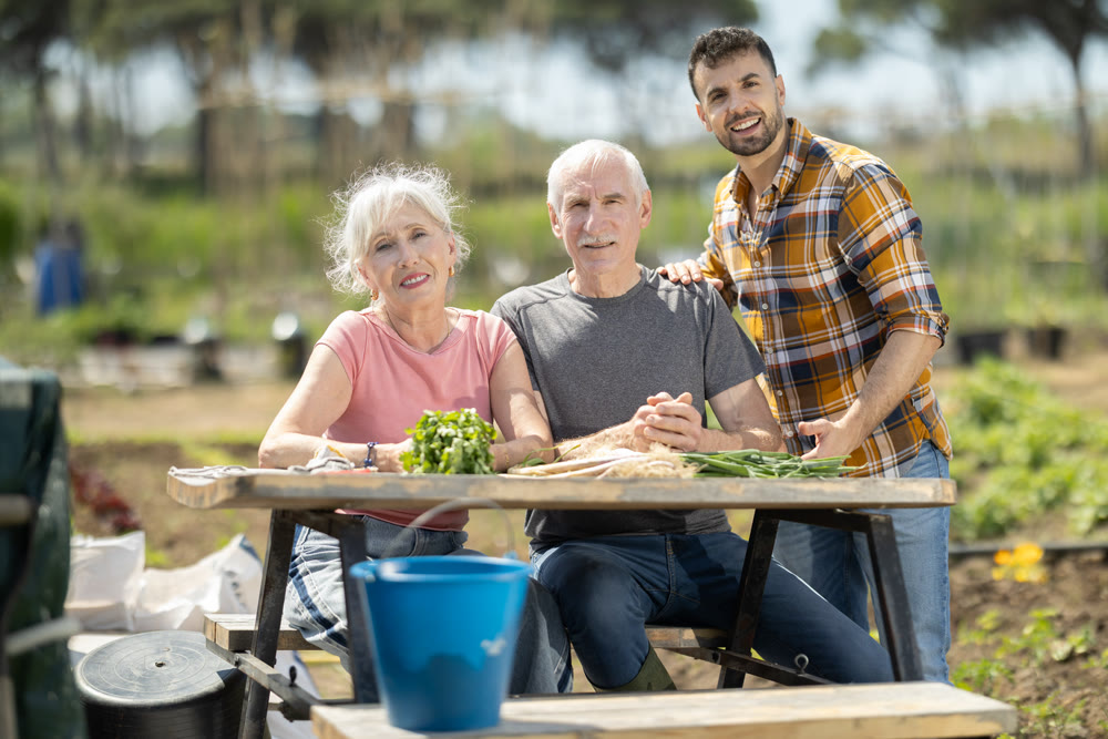 Happy family of farmers sits at table and discusses current affairs