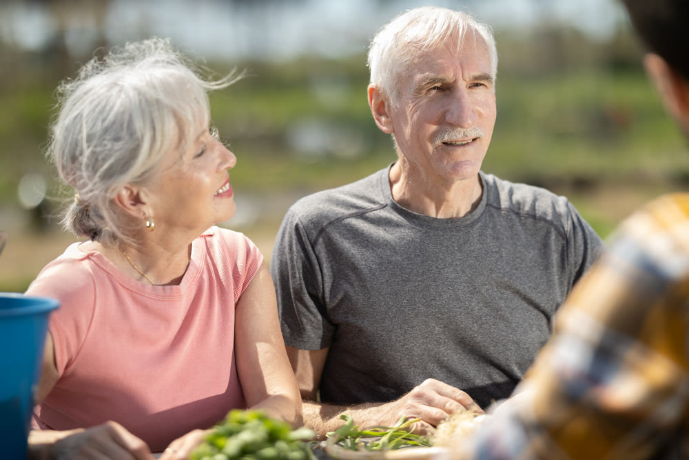 Happy family of farmers sits at table and discusses current affairs
