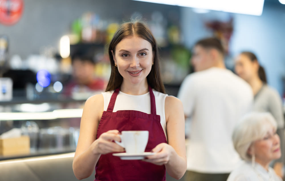 Portrait of female waiter in cafe interior