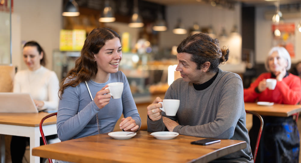 Girl in cafe sits near male companion, has nice conversation