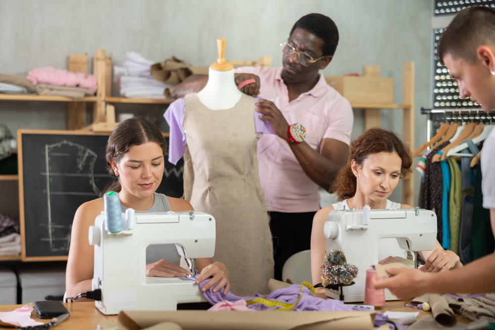 Group of students participating dressmaking class in tailor workshop